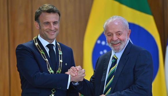 El presidente de Brasil, Luiz Inácio Lula da Silva, condecora al presidente de Francia, Emmanuel Macron, durante una ceremonia este jueves, en el Palacio del Planalto. (EFE/Andre Borges).