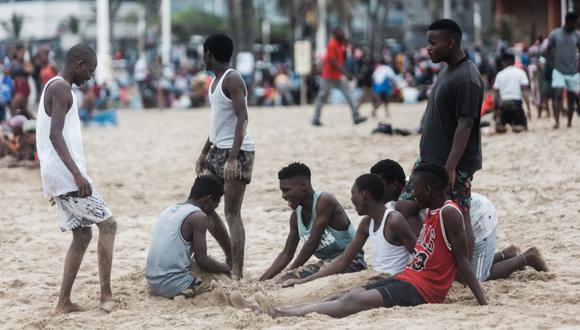 La gente se relaja en la playa a lo largo de la playa de la Milla de Oro de Durban en Durban en medio de un aumento diario de casos de Covid-19. (Foto: RAJESH JANTILAL / AFP).