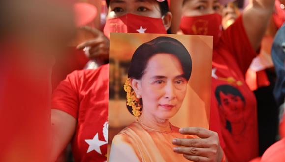Una migrante de Myanmar sostiene una imagen de Aung San Suu Kyi durante una manifestación frente a la embajada de su país en Bangkok el 1 de febrero de 2021. (Foto de Lillian SUWANRUMPHA / AFP).