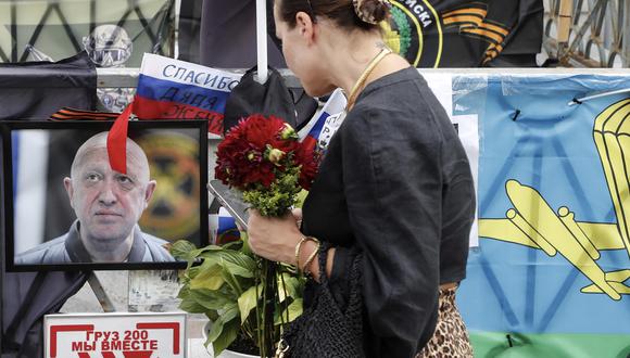 Una mujer sostiene flores frente a un retrato del jefe del Grupo Wagner, Yevgeny Prigozhin. (Foto: EFE/EPA/MAXIM SHIPENKOV)