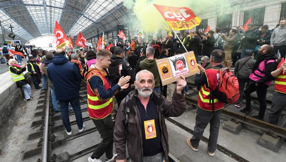 Sindicalistas del sector ferroviario y manifestantes se paran en las vías durante una manifestación un día después de que el gobierno francés impulsara una reforma de las pensiones en el parlamento sin votación, utilizando el artículo 49.3 de la constitución, en la estación de tren de Burdeos, suroeste de Francia, el marzo. 17 de enero de 2023. (Foto de MEHDI FEDOUACH / AFP)