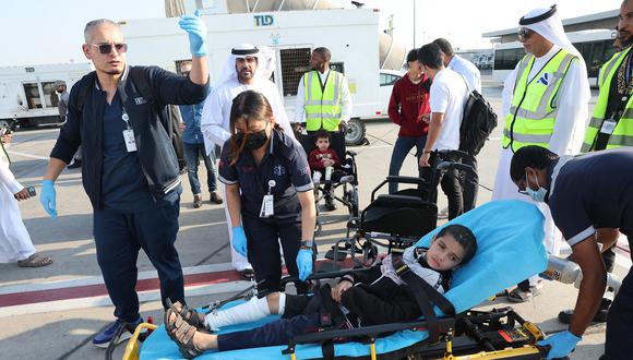 Voluntarios transportan a un niño palestino herido fuera del avión a su llegada a Abu Dabi el 18 de noviembre de 2023, tras ser evacuado de Gaza. (Foto de Giuseppe CACACE / AFP)