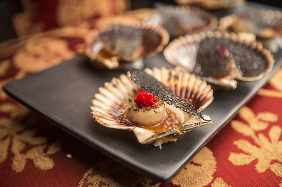 Conchitas Shi-núa, a la brasa con mantequilla, especias y ají limo, coronadas con tobiko (huevas de pez volador).