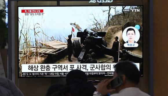 Gente ve una pantalla de televisión que muestra una transmisión de noticias con imágenes de archivos del despido de artillería de Corea del Norte, en una estación de ferrocarril en Seúl el 6 de enero de 2024. (Foto de Jung Yeon-je / AFP)