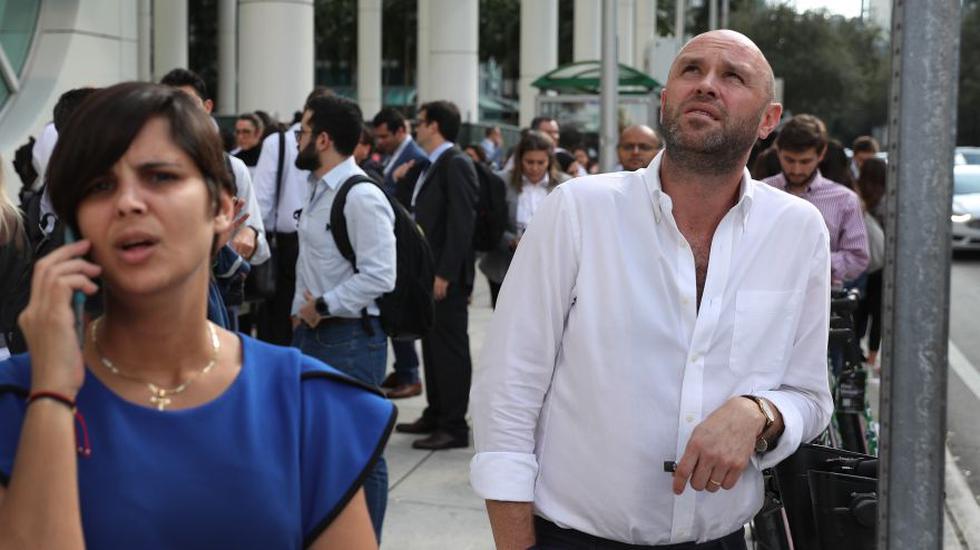 Nicolas Jimenez (derecha) se para afuera de un edificio de oficinas después de que él y otros fueron evacuados después de un terremoto que sacudió el sur de Cuba el 28 de enero de 2020 en Miami, Florida. (Foto: AFP).