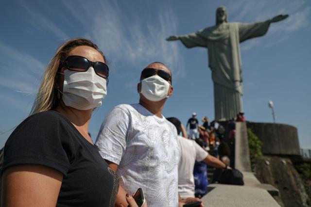 Los turistas disfrutan de una visita a la estatua del Cristo Redentor, en el Cerro Corcovado, Río de Janeiro (Brasil). La apertura de este punto turístico se dio en medio de la pandemia del nuevo coronavirus. (AFP / FABIO MOTTA).