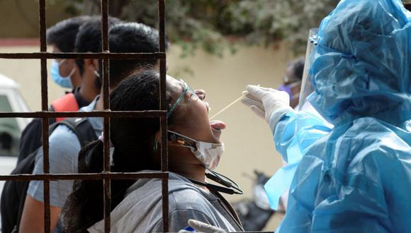 Un trabajador de la salud toma una muestra de hisopo de una mujer para detectar el coronavirus covid-19 en Hyderabad, India, el 12 de enero de 2022. (NOAH SEELAM / AFP).