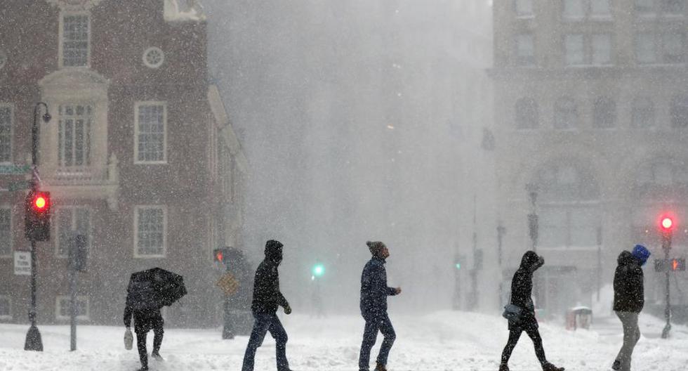 La gente cruza la calle Congress, el sábado 29 de enero de 2022, en Boston. Los meteorólogos observaron de cerca los nuevos récords de nevadas, especialmente en Boston. (Foto AP/Michael Dwyer).