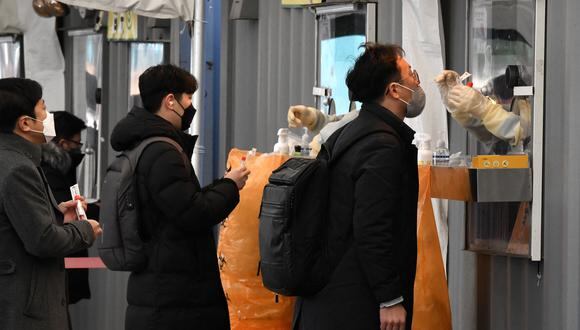 Un personal médico toma un hisopo nasal de un visitante como parte de una prueba del Covid-19 en un centro de pruebas temporal en Seúl el 1 de diciembre de 2021, en medio de la creciente preocupación por la variante Omicron. (Foto de Jung Yeon-je / AFP)