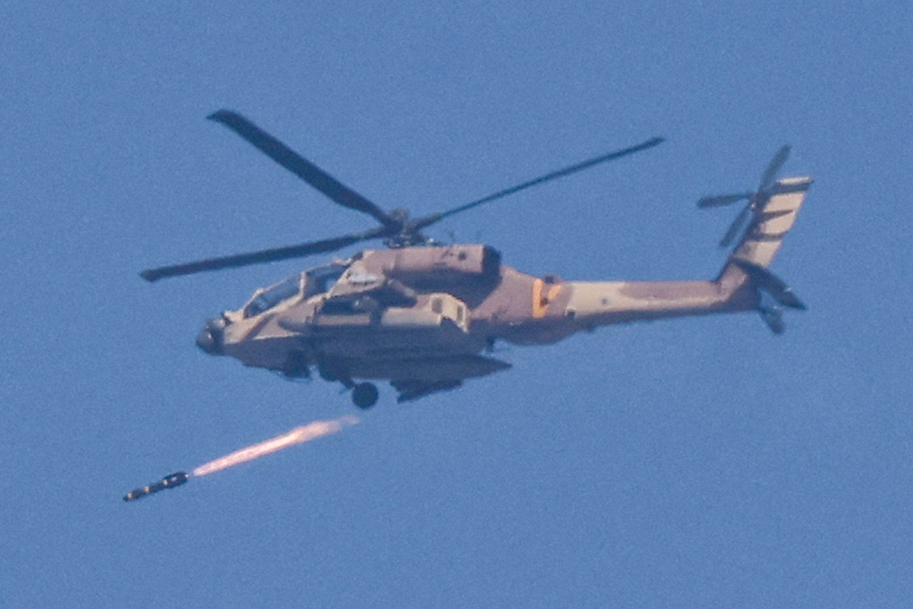 An Israeli Air Force helicopter fires a missile while flying in an area along the border with the Gaza Strip and southern Israel on December 12, 2023. (Photo by JACK GUEZ/AFP).