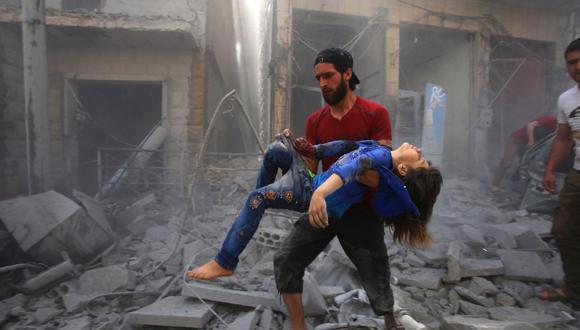 En esta foto de archivo tomada el 26 de mayo de 2019, un hombre evacua a una joven víctima de un bombardeo después de un ataque aéreo de las fuerzas del régimen de Siria y sus aliados en la ciudad de Maaret al-Numan. (Foto de Abdulaziz KETAZ / AFP).