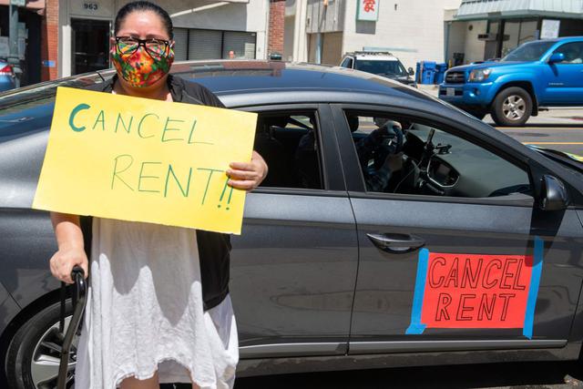 Ady Carrillo posa frente a su automóvil con un letrero que pide suspender los alquileres durante una protesta y caravana en Los Ángeles (California, Estados Unidos). Esto sucede en medio de la crisis por el coronavirus. (AFP / VALERIE MACON).