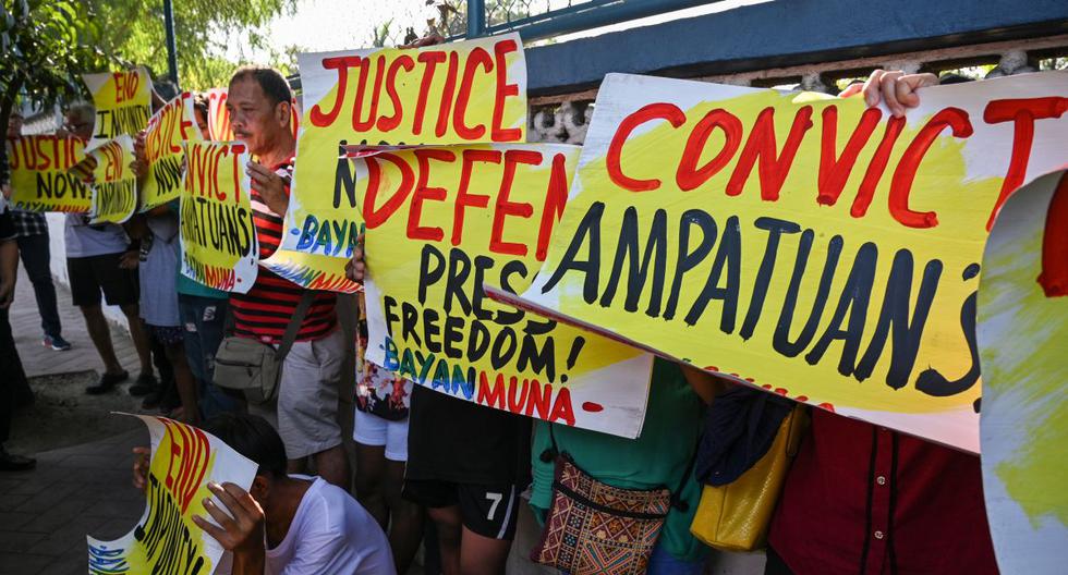 Partidarios y periodistas realizan una manifestación frente a la puerta de la sede del comando capital en Manila antes de un veredicto judicial sobre la masacre de Maguindánao. (AFP)