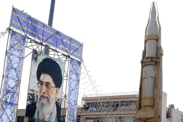 Una fotografía tomada el 27 de septiembre de 2023 muestra un misil tierra-tierra iraní Sejil exhibido junto a un retrato del líder supremo de Irán, el ayatola Alí Jamenei. (Foto de ATTA KENARE / AFP).