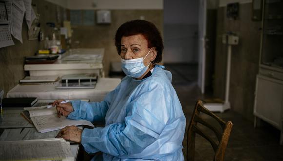 Esta fotografía tomada el 20 de enero de 2021 muestra a la doctora Maria Bogoeva, de 82 años, especialista búlgara en enfermedades infecciosas, trabajando durante su turno en una unidad COVID-19 en el hospital de Doupnitsa. (Dimitar DILKOFF / AFP).