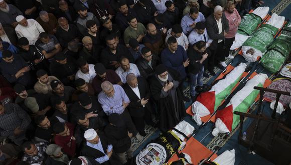 Un clérigo musulmán dirige la oración durante un funeral grupal en la ciudad de Gaza por las personas que murieron en los ataques aéreos israelíes en el territorio palestino a principios del 9 de mayo de 2023. (Foto de MOHAMMED ABED / AFP)