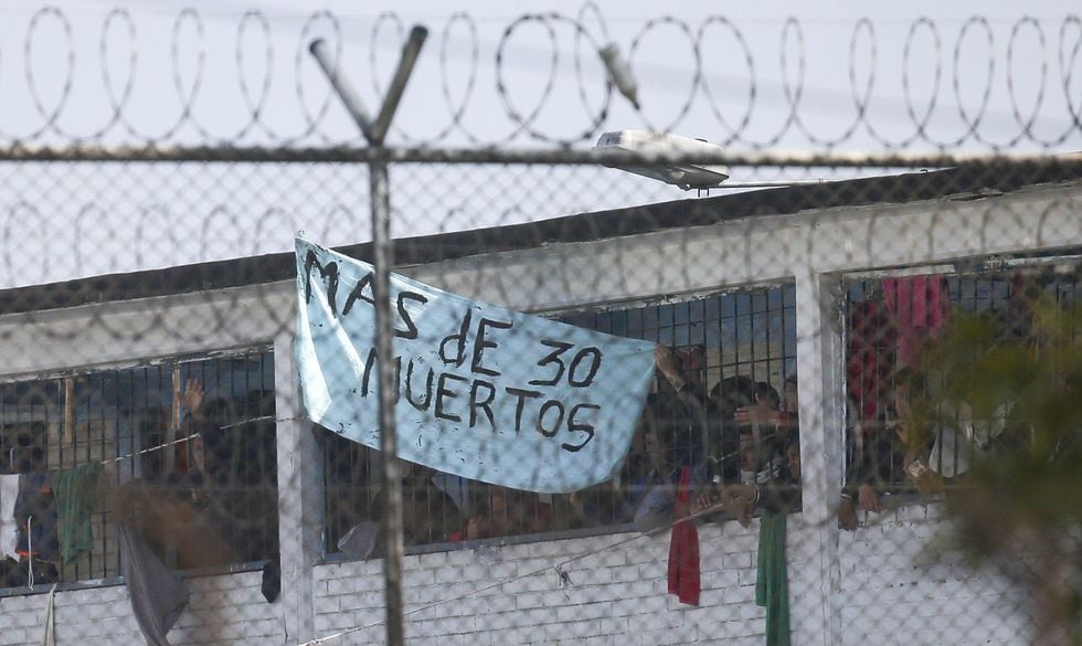 Los internos de la cárcel La Modelo en Bogotá, Colombia, muestran un letrero donde dicen que hay más de 30 muertos. Los presos sostienen que los guardias de la prisión no están haciendo lo suficiente para prevenir el coronavirus dentro de las cárceles superpobladas. (Foto AP / Ivan Valencia).