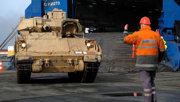 El personal militar descarga un tanque de combate de infantería Bradley de Estados Unidos que llega al puerto de Bremerhaven, en Alemania, para ejercicios militares el 21 de febrero de 2020. (PATRIK STOLLARZ / AFP).