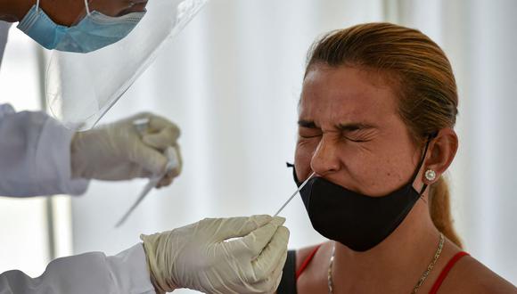 Un trabajador de salud recolecta una muestra de hisopo para una prueba de coronavirus COVID-19 en Cali, Colombia, el 21 de enero de 2021. (Luis ROBAYO / AFP).