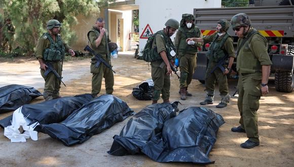 Soldados israelíes se preparan para retirar los cuerpos de sus compatriotas, muertos durante un ataque de militantes palestinos de Hamás en Kfar Aza, al sur de Israel. (Foto de JACK GUEZ / AFP).
