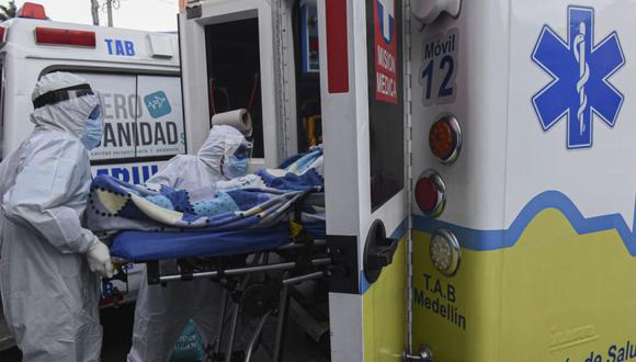 Trabajadores de la salud empujan una camilla con un paciente a una ambulancia mientras la trasladan al Hospital General de Medellín, en medio de la pandemia de COVID-19, en Medellín. (Foto: AFP / JOAQUIN SARMIENTO).