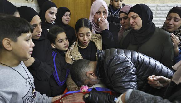 Los familiares lloran por el cuerpo de un hombre muerto durante una incursión israelí nocturna en el campo de refugiados de Tulkarem en la ocupada Cisjordania el 9 de enero de 2024, en medio de continuas batallas entre Israel y el grupo militante palestino Hamas en Gaza. (Foto de Zain JAAFAR / AFP)