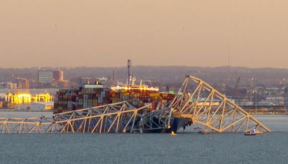 La estructura de acero del puente Francis Scott Key Bridge se encuentra encima de un barco portacontenedores después de que chocó contra el puente en Baltimore, Maryland, el 26 de marzo de 2024. (Foto de Jim WATSON / AFP)