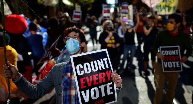 Una persona sostiene un cartel que dice "Cuente cada voto" mientras la gente se manifiesta fuera del Centro de Convenciones de Filadelfia, donde los votos todavía se cuentan dos días después de las elecciones presidenciales de EE. UU. en Filadelfia, Pensilvania. (REUTERS / Mark Makela).
