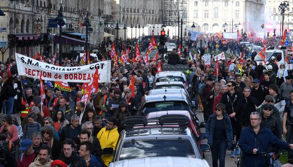 Los automóviles circulan entre los manifestantes durante una manifestación en el octavo día de huelgas y protestas en todo el país contra la reforma de las pensiones propuesta por el gobierno en Burdeos el 15 de marzo de 2023. (Foto de MEHDI FEDOUACH / AFP)