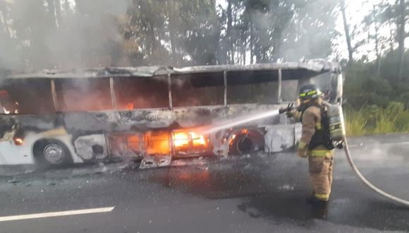 Bomberos mientras trabajan para apagar un incendio en un bus que trasladaba a 57 migrantes, en la carretera panamericana. (Foto de Relaciones Públicas Del Cuerpo De Bomberos De Panamá / EFE)