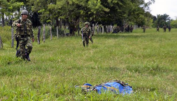 Soldados colombianos caminan cerca del cadáver de un soldado asesinado tras un ataque en el departamento de Arauca, Colombia. (Foto referencial: DANIEL MARTINEZ / AFP)