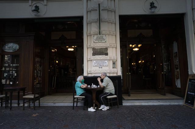 Una pareja toma un café en el famoso café Tortoni en el centro de Buenos Aires, Argentina, el viernes 12 de marzo de 2021. Según el gerente Miguel González, el Tortoni, que alguna vez sirvió a artistas como el gran escritor Jorge Luis Borges y el cantante de tango Carlos Gardel, ha vio sus ventas colapsar hasta en un 80% debido a la crisis económica agravada por la pandemia. (AP Foto/Víctor R. Caivano).