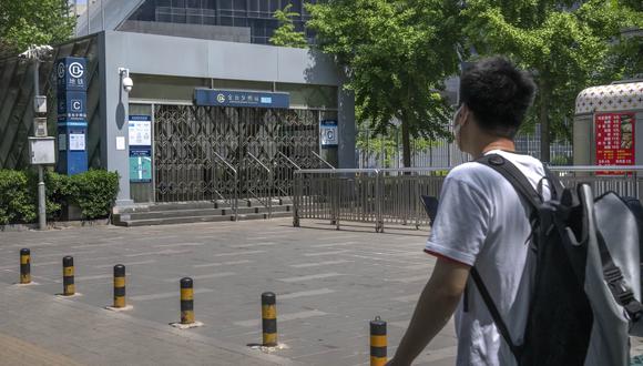 Hombre mirando la estación de metro cerrada en Beijing. (AP/Mark Schiefelbein)