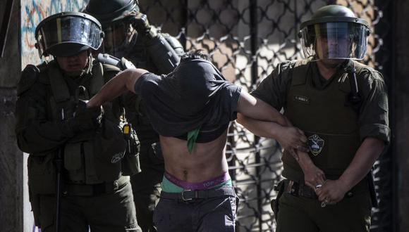 Un manifestante es arrestado por la policía antidisturbios durante las protestas del 29 de octubre de 2019 en Santiago de Chile. (Foto de Pedro Ugarte / AFP).