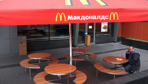 Un hombre habla por teléfono mientras se sienta en una mesa de un restaurante McDonald's cerrado, el primero que se abrió en la Unión Soviética en 1990, en Moscú el 21 de agosto de 2014. (Foto: ALEXANDER NEMENOV / AFP)