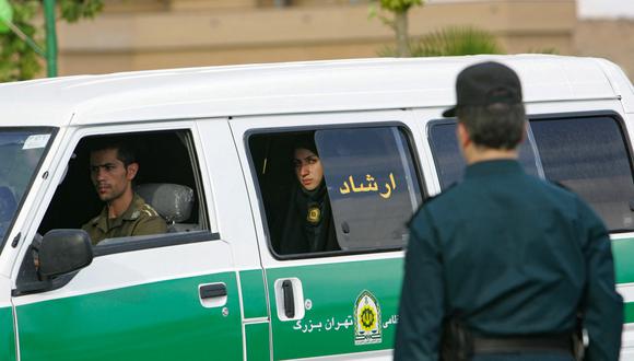 En esta foto de archivo, una mujer policía iraní observa desde la parte trasera de un vehículo policial antes del comienzo de una campaña para hacer cumplir el código de vestimenta islámico en la capital, Teherán. (Foto: Behrouz MEHRI / AFP)