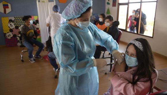 Una adolescente recibe una dosis de la vacuna Pfizer-BioNTech contra el coronavirus COVID-19 en la Fundación Cecilia Rivadeneira en Quito, Ecuador, el 21 de julio de 2021. (RODRIGO BUENDIA / AFP).