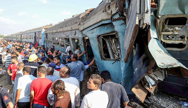 People gather at the site of a train collision in the area of Khorshid, in Egypts Mediterranean city of Alexandria, on August 11, 2017. At least 36 people were killed as two trains collided outside of Alexandria, in one of the deadliest in a string of such accidents in Egypt, the health ministry said. / AFP