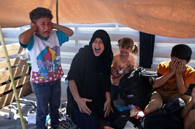Mujeres y niños refugiados y migrantes lloran en medio de las protestas y represión en el destruido campo de Moria. (REUTERS/Alkis Konstantinidis).