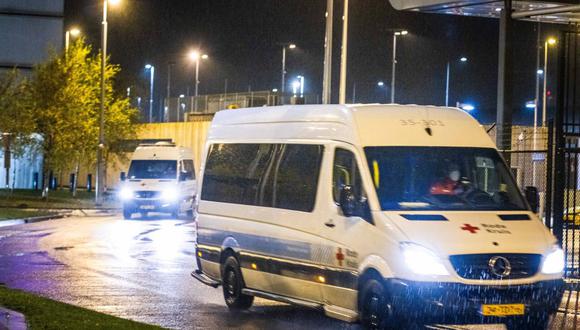 Camionetas de la Cruz Roja transportan hacia un hotel a pasajeros de vuelos desde Sudáfrica que dieron positivo al coronavirus a su llegada a Países Bajos. (LAURENS BOSCH / ANP / AFP).