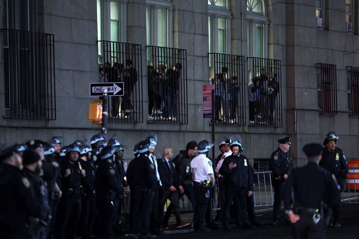 Estudiantes miran por una ventana mientras los agentes de la policía de Nueva York desalojan un edificio en la Universidad de Columbia, en la ciudad de Nueva York, el 30 de abril de 2024. (Foto de CHARLY TRIBALLEAU / AFP)