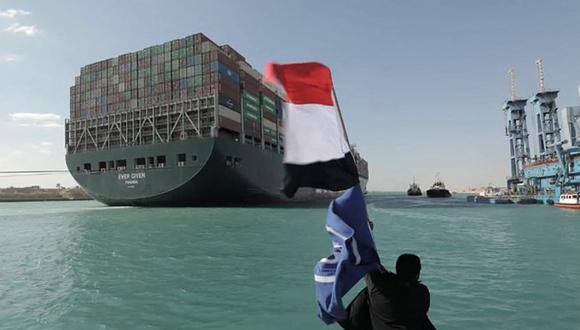 Una imagen publicada por la Autoridad del Canal de Suez de Egipto el 29 de marzo de 2021 muestra a un hombre ondeando la bandera egipcia después de que el portacontenedores Ever Given fuera desencallado del Canal de Suez. (AFP).