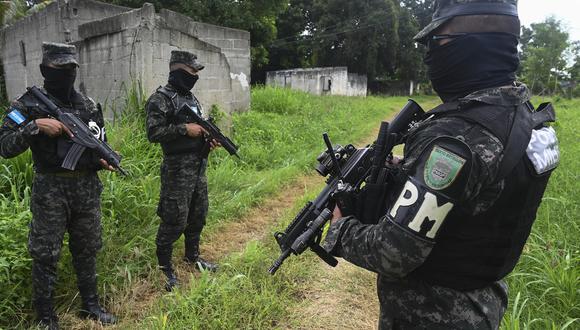 Miembros de la Policía Militar de Orden Público (PMOP) caminan cerca de una casa abandonada en Chamelecón, en los suburbios de San Pedro Sula, Honduras, el 16 de julio de 2022. (Foto: AFP / Orlando SIERRA)