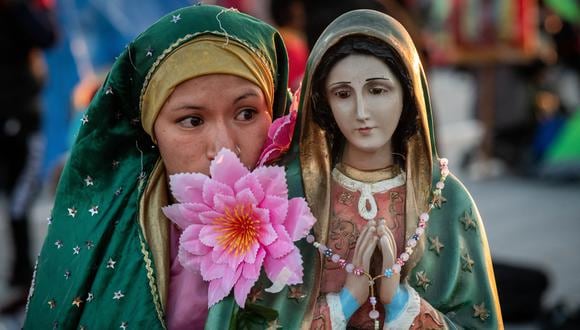 Un peregrino junto a una imagen de la Virgen de Guadalupe afuera de la Basílica de Guadalupe en la Ciudad de México.