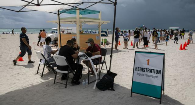 Las personas se registran para recibir una vacuna Johnson & Johnson Covid-19 en un centro de vacunación emergente en la playa, en South Beach, Florida. (Foto: Eva Marie UZCATEGUI / AFP).