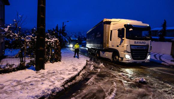 Una foto tomada cerca de Tournon-sur-Rhone, muestra un camión conduciendo por una carretera cubierta de nieve. (AFP)