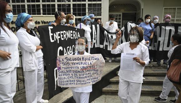 Enfermeras y paramédicos venezolanos de hospitales estatales participan en una manifestación frente al edificio de la Defensoría del Pueblo en demanda de mejores salarios pagados en dólares y medicinas para atender a los pacientes afectados por la pandemia provocada por el COVID-19, en Caracas. (Foto: Archivo/ Yuri CORTEZ / AFP)