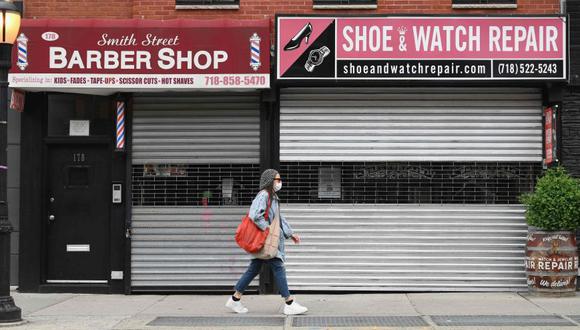 Una mujer caminando por negocios cerrados en Brooklyn, Nueva York. (Foto: AFP / Angela Weiss)