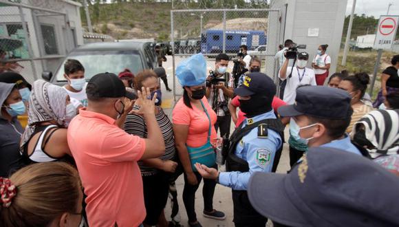 Familiares de reclusos del penal de alta seguridad La Tolva conversan con la policía durante las peleas entre los presos del Barrio 18 y la pandilla rival MS-13, en Moroceli, Honduras. (Foto: REUTERS / Fredy Rodríguez).