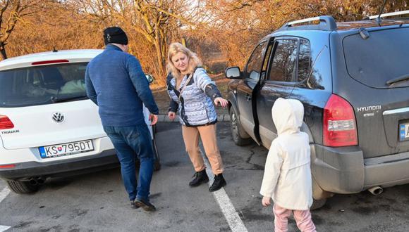 Se ve a una familia ucraniana después de llegar desde su ciudad natal de Uzgorod, Ucrania, al cruce fronterizo de Zahony, a unos 350 km de la capital húngara, Budapest. (Foto: ATTILA KISBENEDEK / AFP)